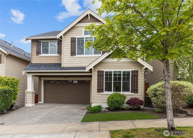 craftsman inspired home with roof with shingles, an attached garage, and concrete driveway