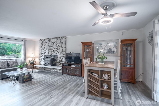 3515 W Tapps Dr E, Lake Tapps, WA 98391 - living area with crown molding, a ceiling fan, wood finished floors, and a wood stove