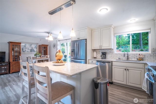 3515 W Tapps Dr E, Lake Tapps, WA 98391 - kitchen featuring a kitchen island, stainless steel appliances, a sink, and light wood-type flooring