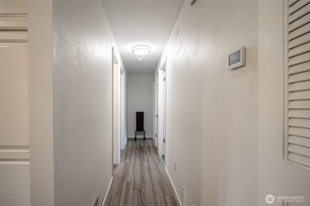 3515 W Tapps Dr E, Lake Tapps, WA 98391 - corridor with baseboards, a textured wall, wood finished floors, and visible vents