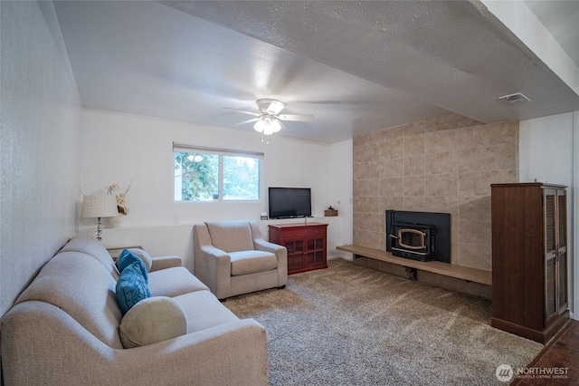 3515 W Tapps Dr E, Lake Tapps, WA 98391 - living area with carpet flooring, ceiling fan, visible vents, and a wood stove