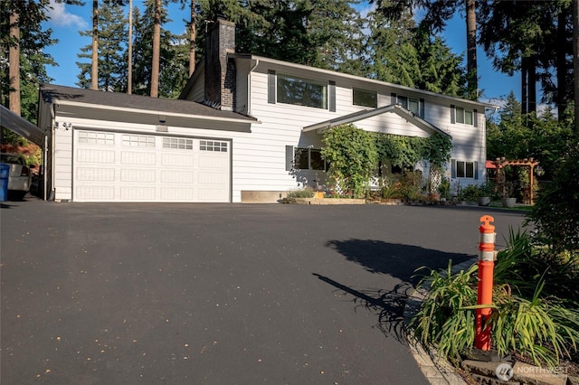 3515 W Tapps Dr E, Lake Tapps, WA 98391 - view of front of home featuring a garage, a chimney, and aphalt driveway