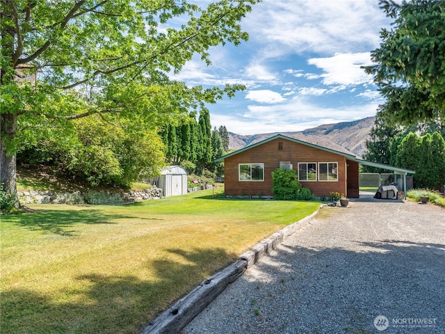 13555 Hillcrest Dr, Entiat, WA 98822 - view of home's exterior with a shed, an outbuilding, a lawn, a carport, and driveway