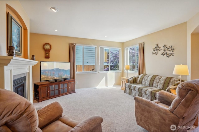 living area featuring a tiled fireplace, carpet floors, baseboards, and recessed lighting