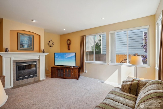 living room featuring baseboards, recessed lighting, carpet, and a tile fireplace