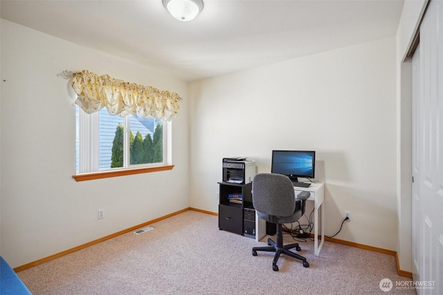 carpeted office space with baseboards and visible vents