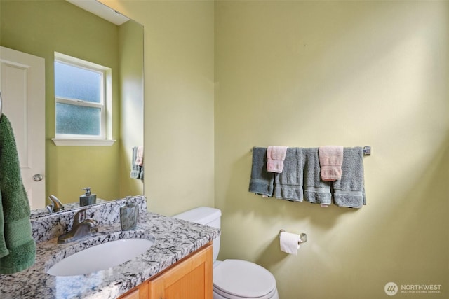 half bathroom with vanity and toilet