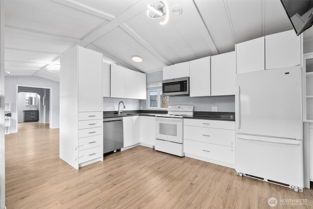 kitchen featuring dark countertops, appliances with stainless steel finishes, lofted ceiling with beams, light wood finished floors, and white cabinetry