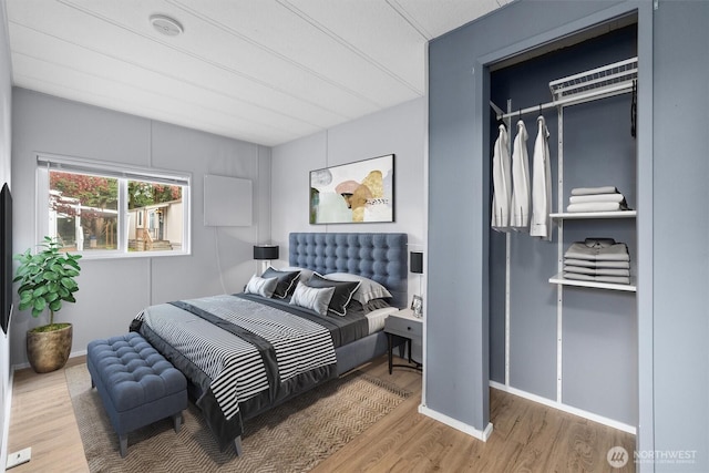 bedroom with baseboards and wood finished floors
