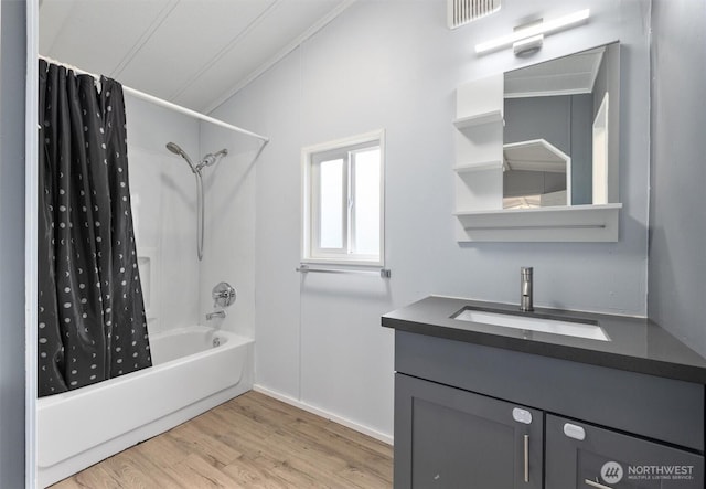 bathroom with visible vents, wood finished floors, shower / tub combo, vanity, and ornamental molding
