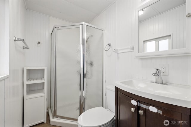 full bathroom with vanity, a shower stall, and toilet