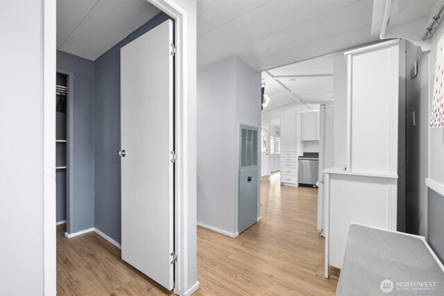hallway with light wood-type flooring and baseboards
