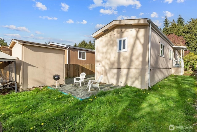 rear view of property featuring a lawn and fence