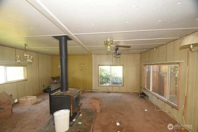 unfurnished living room featuring a healthy amount of sunlight and a wood stove