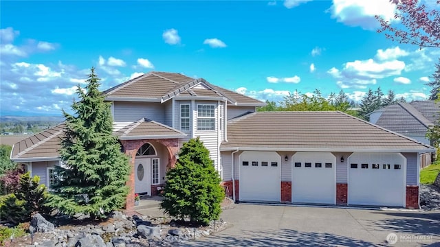 5801 51st Avenue Ct E, Tacoma, WA 98443 - view of front of house with an attached garage, a tiled roof, brick siding, and driveway