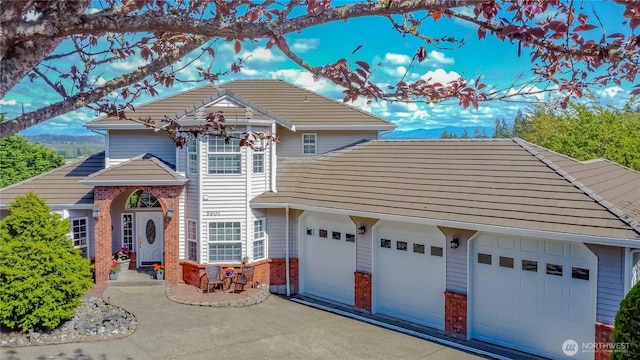 5801 51st Avenue Ct E, Tacoma, WA 98443 - view of front of house featuring an attached garage, driveway, a tile roof, and brick siding