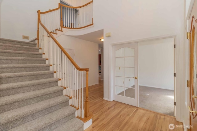 5801 51st Avenue Ct E, Tacoma, WA 98443 - stairs featuring baseboards, a high ceiling, french doors, and wood finished floors