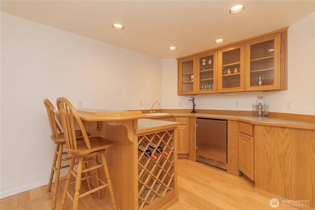 5801 51st Avenue Ct E, Tacoma, WA 98443 - kitchen featuring light wood-style floors, dishwashing machine, a peninsula, and a breakfast bar area