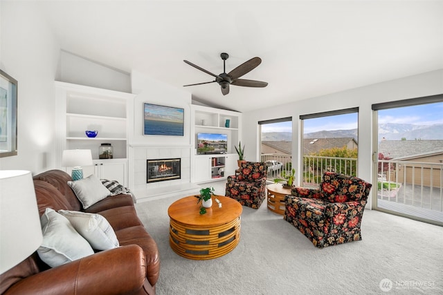 351 19th St NE Unit 10, East Wenatchee, WA 98802 - living room with a ceiling fan, a tiled fireplace, built in features, carpet floors, and lofted ceiling