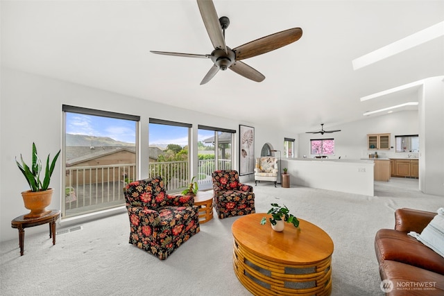 351 19th St NE Unit 10, East Wenatchee, WA 98802 - living area with light colored carpet, a ceiling fan, and lofted ceiling with skylight