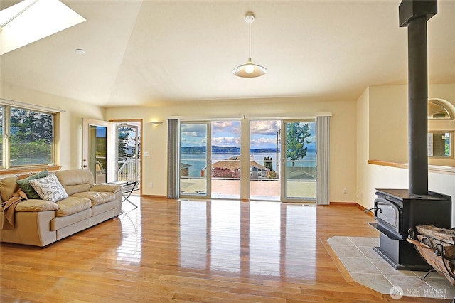 2279 Elger Park Rd, Camano Island, WA 98282 - living room with a wood stove, light wood finished floors, lofted ceiling, baseboards, and a skylight