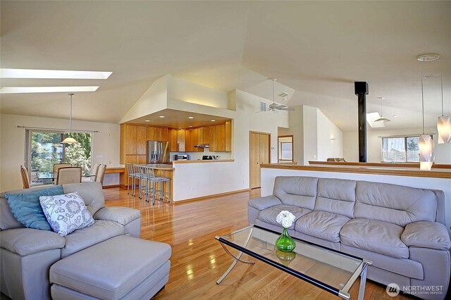 2279 Elger Park Rd, Camano Island, WA 98282 - living area featuring vaulted ceiling, a skylight, and light wood-style flooring