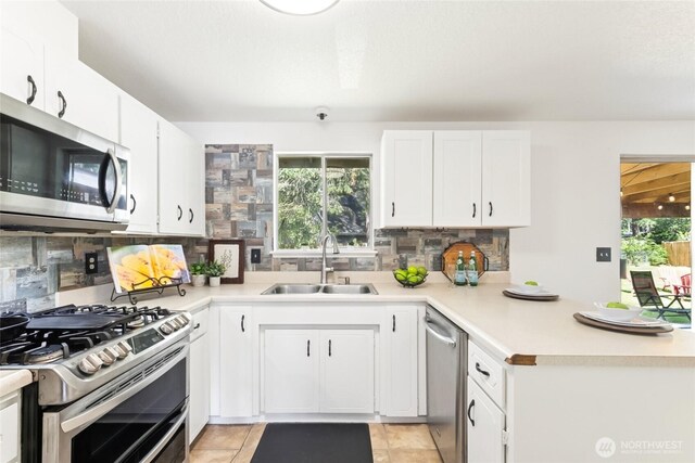 kitchen featuring a sink, decorative backsplash, stainless steel appliances, and a wealth of natural light