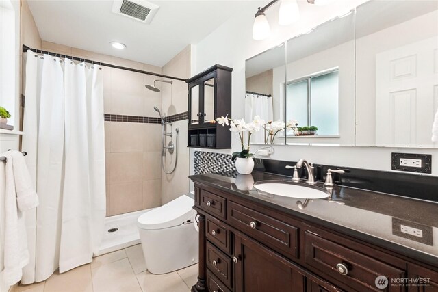 bathroom with visible vents, tile patterned floors, a tile shower, and toilet