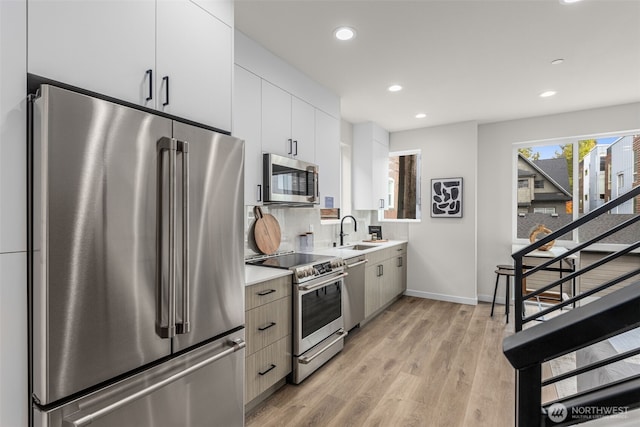 1124C 13th Ave, Seattle, WA 98122 - kitchen featuring appliances with stainless steel finishes, a sink, recessed lighting, light countertops, and light wood finished floors