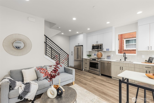 1124C 13th Ave, Seattle, WA 98122 - kitchen featuring appliances with stainless steel finishes, a sink, light countertops, light wood-style flooring, and open floor plan