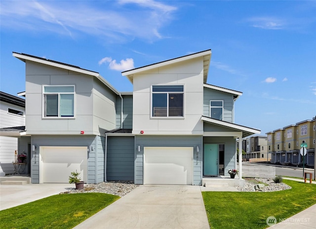 contemporary home featuring concrete driveway, an attached garage, and a front lawn