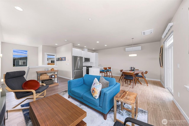 living area featuring recessed lighting, baseboards, light wood-type flooring, and visible vents