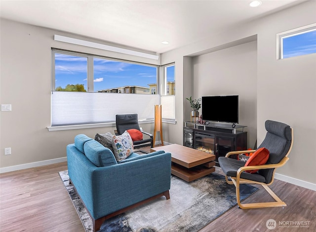 living area featuring baseboards, recessed lighting, and wood finished floors