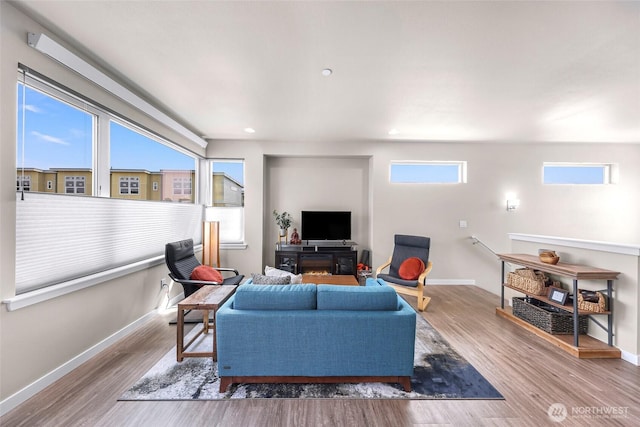 living area with baseboards, recessed lighting, and wood finished floors