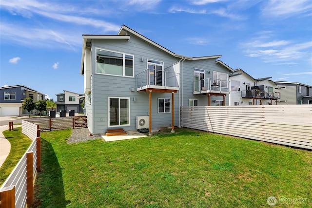 rear view of house featuring a lawn, a residential view, ac unit, and a fenced backyard