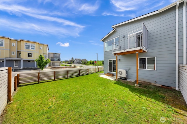 view of yard with a residential view, ac unit, a fenced backyard, and a balcony
