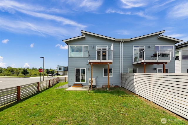 rear view of house featuring a fenced backyard and a yard