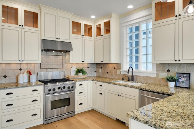 3122 SW 172nd St, Burien, WA 98166 - kitchen featuring stainless steel range with gas stovetop, under cabinet range hood, a sink, light wood-type flooring, and light stone countertops
