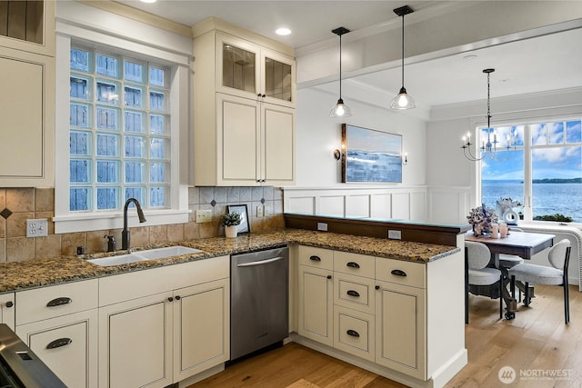 3122 SW 172nd St, Burien, WA 98166 - kitchen featuring stainless steel dishwasher, a sink, a peninsula, healthy amount of natural light, and a wainscoted wall