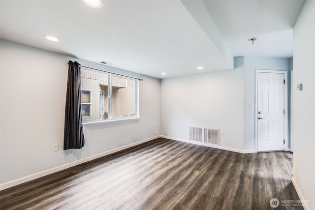 unfurnished room with visible vents, baseboards, and wood finished floors