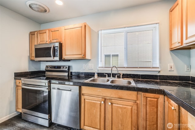 kitchen with appliances with stainless steel finishes, a sink, dark wood finished floors, tile countertops, and visible vents