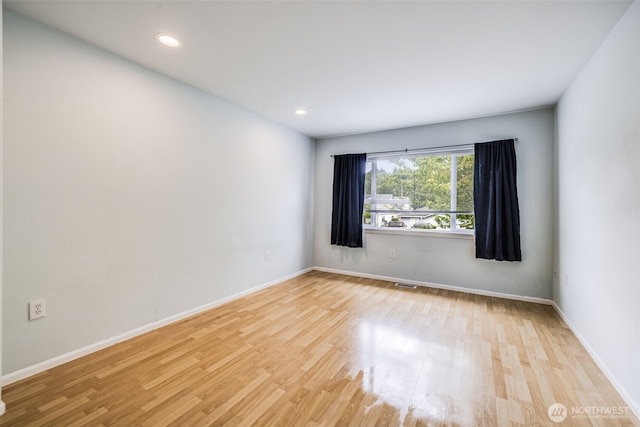 empty room with baseboards, recessed lighting, and wood finished floors