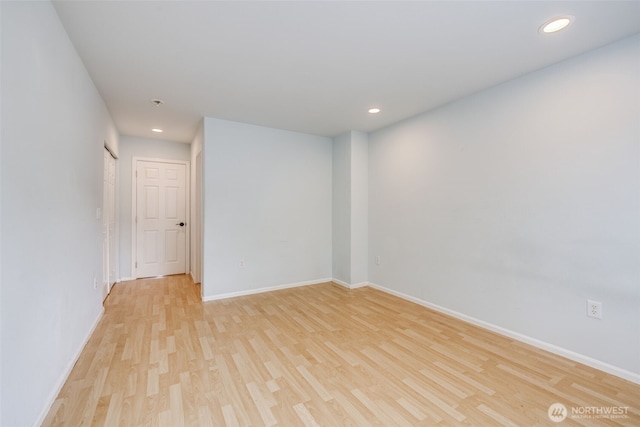 unfurnished room featuring recessed lighting, baseboards, and light wood-type flooring