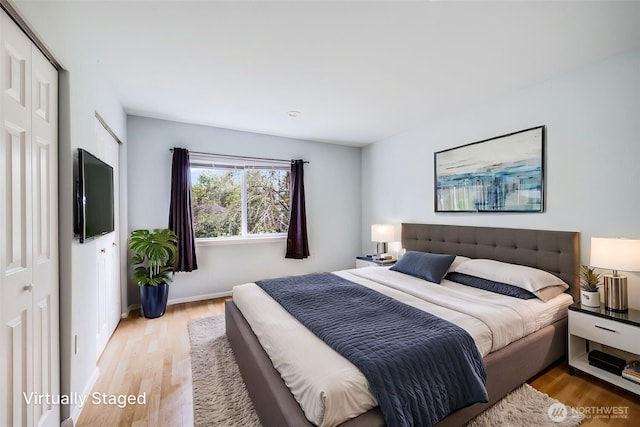 bedroom with baseboards, light wood finished floors, and a closet
