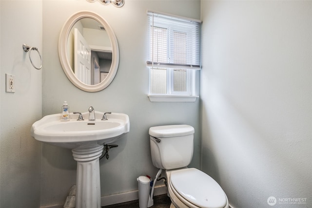 bathroom featuring baseboards and toilet