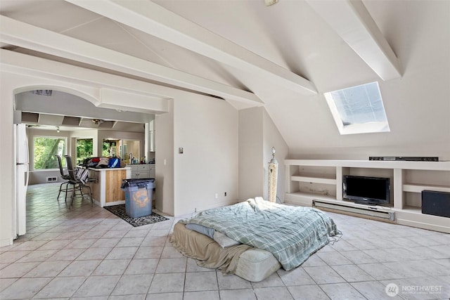 bedroom featuring freestanding refrigerator, lofted ceiling with skylight, and light tile patterned flooring
