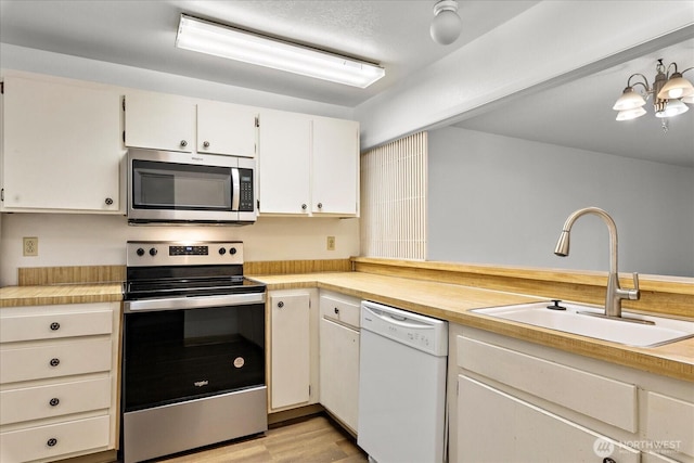6702 139th Ave NE Unit 742, Redmond, WA 98052 - kitchen with a sink, light countertops, light wood-style floors, stainless steel appliances, and white cabinetry