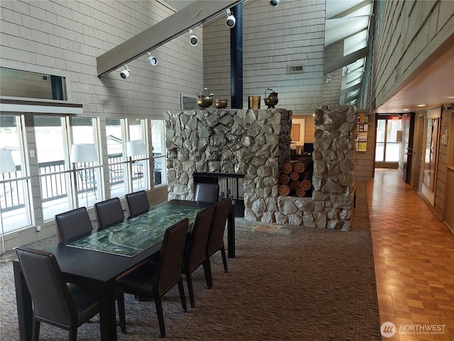 6702 139th Ave NE Unit 742, Redmond, WA 98052 - dining space with track lighting, a towering ceiling, visible vents, and a fireplace