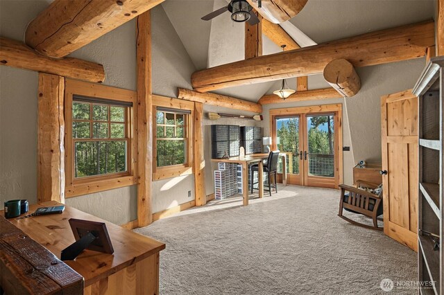 carpeted living room featuring a textured wall, lofted ceiling with beams, french doors, and ceiling fan