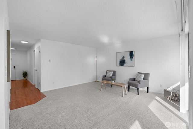 living area featuring carpet flooring and baseboards